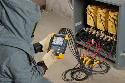 A technician using a power quality analyzer in the field.